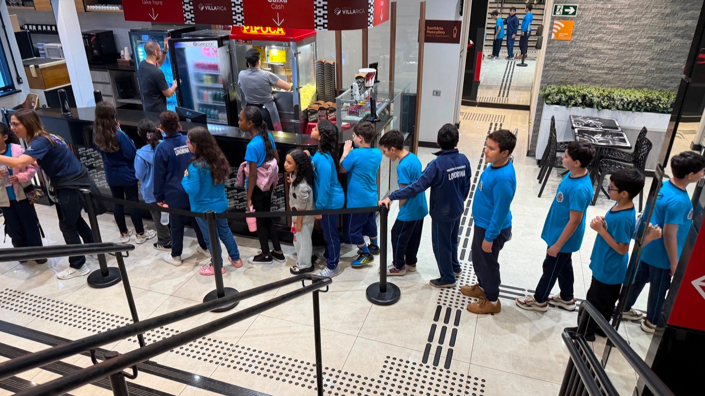 Grupo de estudantes sorrindo na galeria do Villa Rica