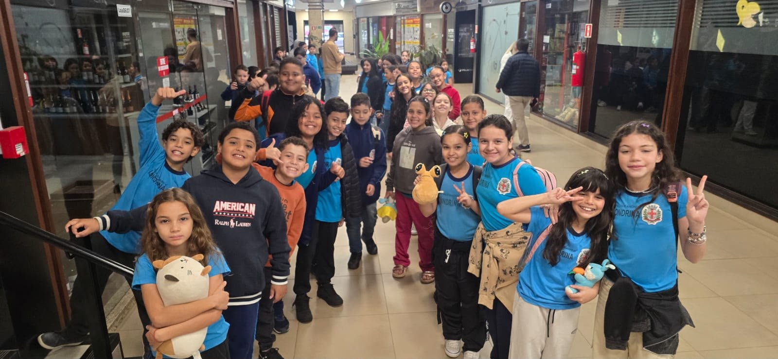 Estudantes escolhendo pipoca e bebidas no foyer do Villa Rica